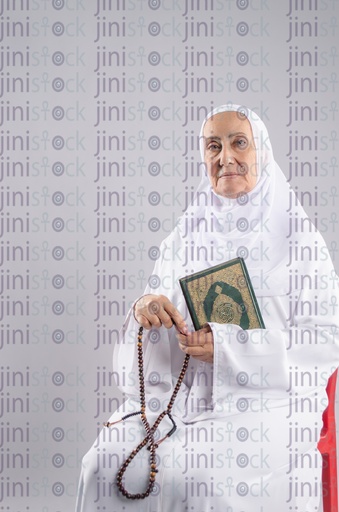 Old Egyptian woman holding Qur'an and sabha