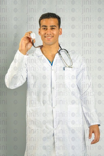 A male Egyptian doctor wearing a white coat and holding a stethoscop.e in his hand