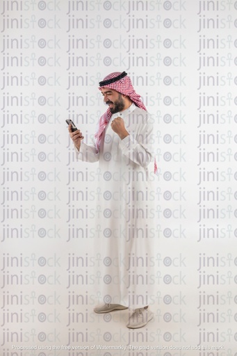 Khaliji man looking at his phone happy winning