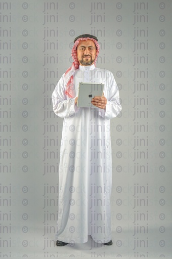 Khaliji Saudi Arabian or Emirati man or a man from the Gulf holding a tablet computer and looking at the camera