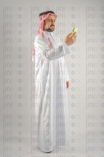 Khaleeji man Saudi, Emirati, or a Gulf man browsing a mobile application or texting on an mobile app.