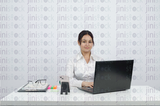 Woman working on laptop and smiling - frontal close-up - stock image