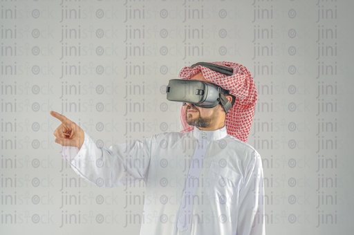 Khaliji man from Saudi Arabia or UAE wearing VR glasses and touching a screen