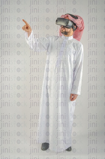 Khaliji man from Saudi Arabia or UAE wearing VR glasses and touching a screen