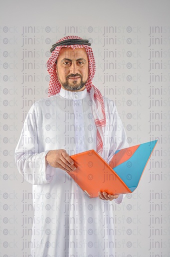 A man from the Gulf Saudi or Emirati holding a folder of work papers.