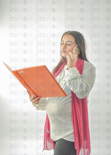 An Egyptian pregnant woman working, reviewing the file in her hand while talking on the cell phone