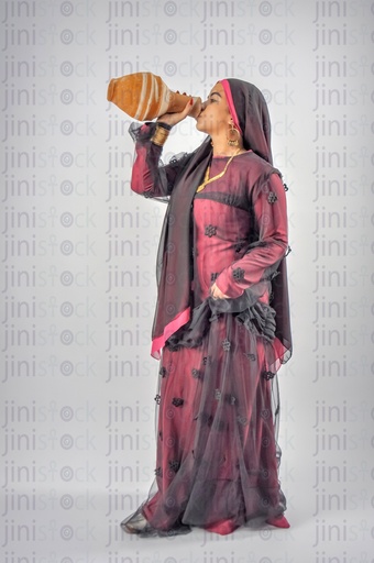 Nubian Egyptian woman wearing Nubian clothes or farmer drinking water from Qola