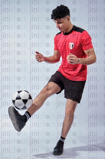 young egyptian man wearing the national team shirt playing with football