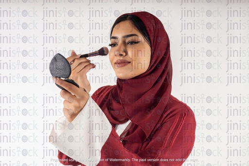 a stock image of a khaliji woman doing makeup on isolated background