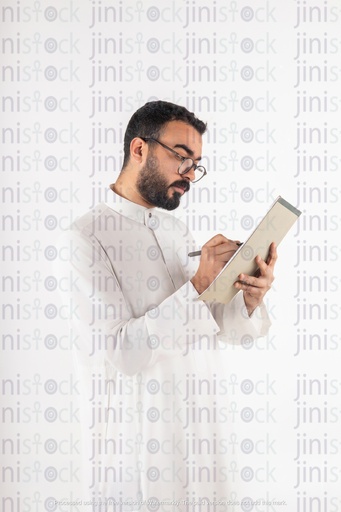 صورة فوتوغرافية لرجل أعمال خليجي سعودي يكتب على الأوراق