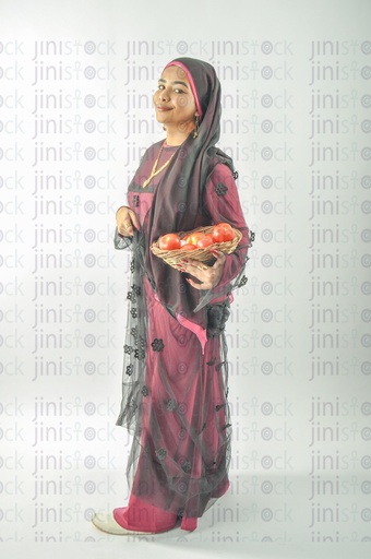 A farmer or a Nubian woman from Egypt wearing Nubian clothes and holding a plate of tomatoes in her hands