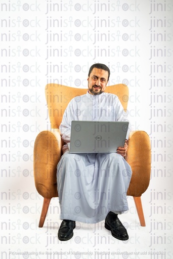 saudi khaliji man from gulf sitting on a chair working on his laptop