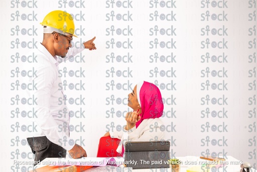 A veiled Nubian girl sitting next to a Nubian young man wearing a yellow hat