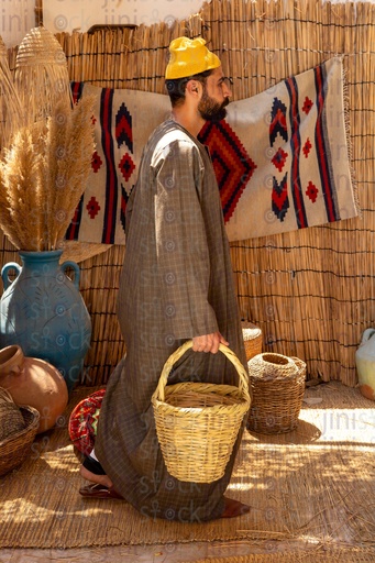 Egyptian farmer carrying a wicker basket 