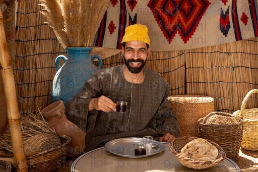 Egyptian man in a wicker hut drinking tea 