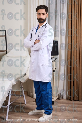 An Egyptian doctor standing in his clinic wearing a medical coat and a stethoscope
