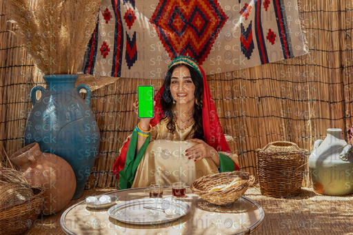Egyptian girl sitting holding a phone with a green screen