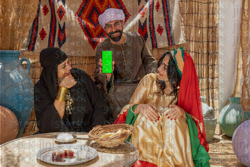 A young man sitting between a woman and a young woman looking at their phones and laughing