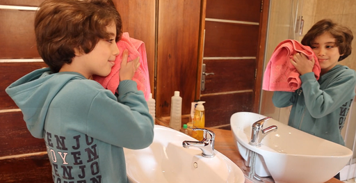 Egyptian boy washing his face in the bathroom sink