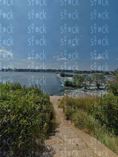 Reflections of the blue sky on the Rashid branch next to the crops