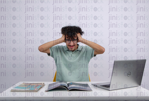 a young man with curly hair feeeling stressed - stock image