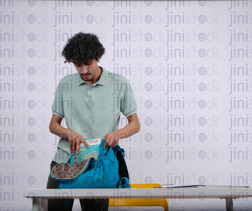 young student packing his back bag - stock image